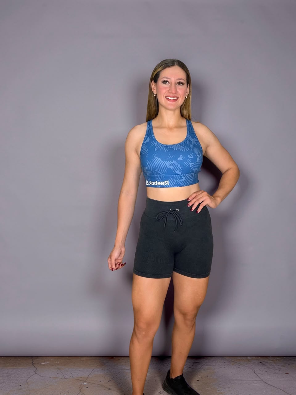 Blue camo Reebok sports bra and black drawstring shorts